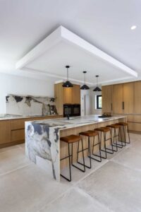 Verta kitchen island with four leather stools and oak cabinetry