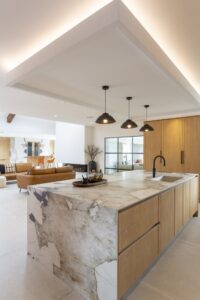 Verta waterfall island with oak drawers and a dark tap