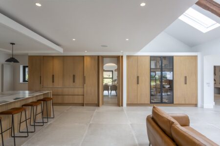 Verta concealed doorway set within full-height oak cabinetry
