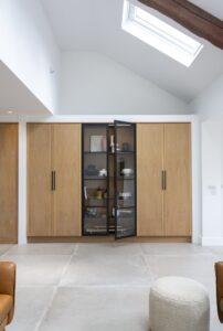 Full-height glazed display cupboard framed by Verta oak cabinetry