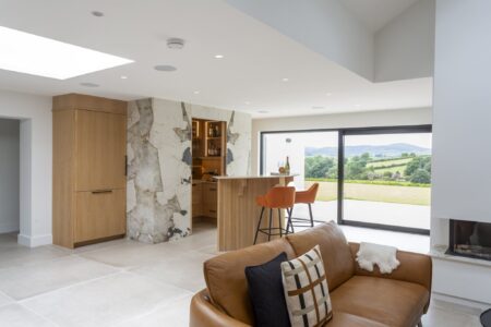 Verta home bar with orange stools beside garden-facing windows