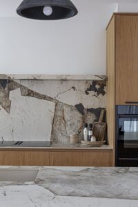 Verta cooking area with veined splashback and oak drawers