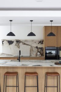 Verta island and cooking area beneath three pendant lights
